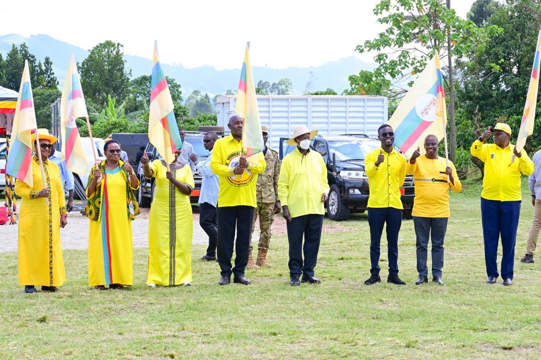 President Museveni who is also the NRM presidential candidate hands over the party flag to Mrs Jackline Mbabazi and Dr Chris Baryomunsi during a campaign rally at Rwere play grounds in Kinkinzi East in Kanu